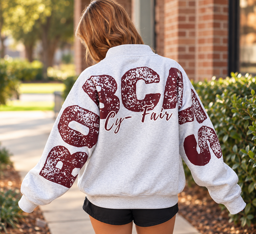 Lifestyle example: ash heather oversized varsity sweatshirt with distressed burgundy lettering and script detail